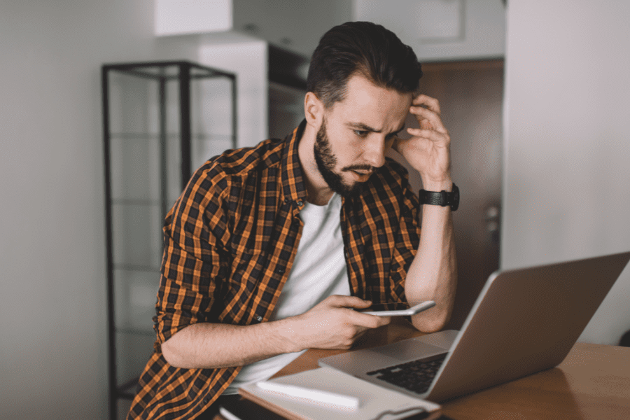 A man researching the costs of home emergency cover on his laptop.